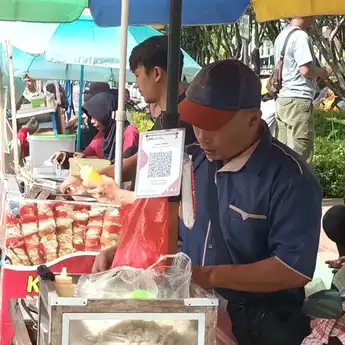 Ade, Pedagang Jajanan Kaki Lima Ikut Gunakan QRIS dalam Bertransaksi