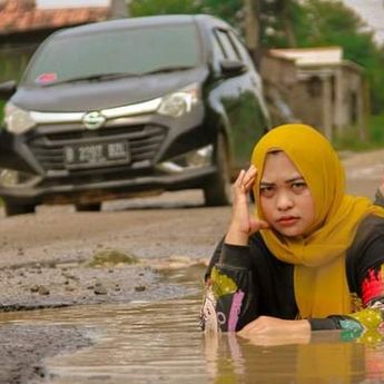 Viral Sindir Pemerintah, Suami Istri Berfoto Bak Model di Jalan Rusak 