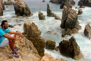 Pembawa acara Explore Indonesia, Kamga, berada di Pantai Gigi Hiu, Lampung.