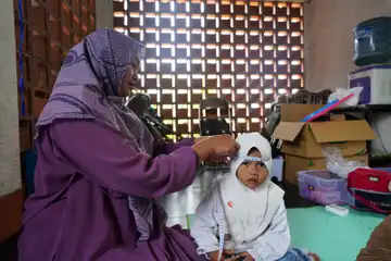 Petugas Posyandu Cimenyan sedang mengukur lingkar kepala anak pada Program Posyandu Sejahtera, Cimenyan Kab. Bandung.