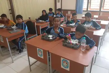 Anak - Anak Sekolah sedang menikmati menu Makan Bergizi Gratis, Senin (17/2/2025).