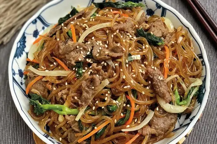 Japchae yang disajikan dalam piring tradisional Korea