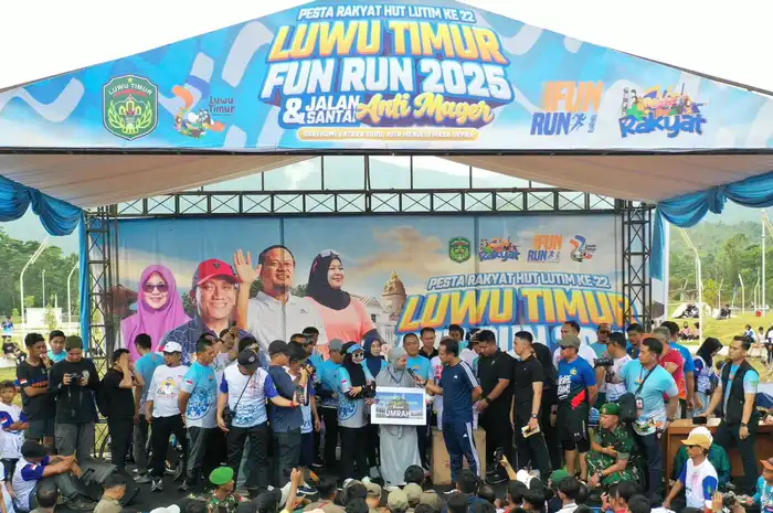 Gubernur Sulawesi Selatan, Andi Sudirman Sulaiman, menyerahkan hadiah umrah kepada Nurlina, bidan PNS dari UPTD Puskesmas Berau, yang tak kuasa menahan tangis haru setelah namanya diumumkan sebagai pemenang undian dalam acara Fun Run Luwu Timur 2025 dan Gerakan Anti Mager Sulsel, Minggu (18/5/2025).