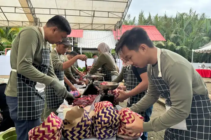 Petugas kurban Pertamina tampak mengemas daging menggunakan besek bambu.