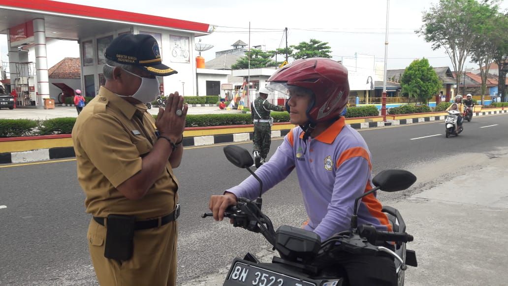 : Kepala Badan Kesbangpol Kota Pangkalpinang, Anggo Rudi, memberikan sosialisasi persuasif kepada pengendara motor yang tidak memakai masker di Jl. Soekarno Hatta, Selasa (28/7/20).