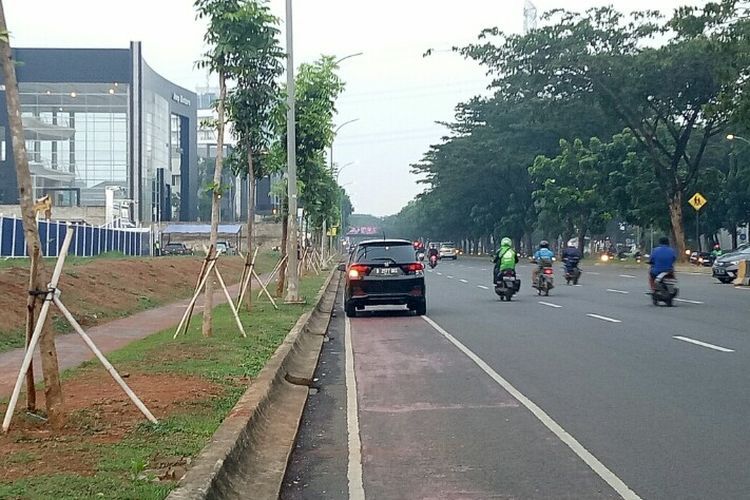 Sejumlah pengendara baik motor dan mobil berhenti jalur sepeda yang berada di Jalan Boulevard Bintaro Sektor 7, Pondok Aren, Tangerang Selatan.  (KOMPAS.com/Muhamad Isa Bustomi)  