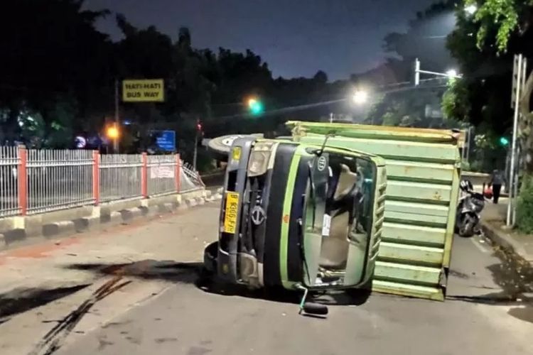 Truk boks bermuatan sembako terguling di Jalan Raya Pondok Gede, Kramat Jati, Jakarta Timur, Minggu (5/4/2020). Petugas evakuasi menyebutkan truk berbobot 13 ton itu mengangkut sembako untuk dipasok menuju minimarket di Jakarta.   (ANTARA/HO-Damkar Jaktim)  