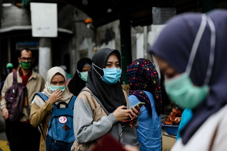 Warga menggunakan masker setelah melewati jembatan penyebrangan orang (JPO) dari stasiun Palmerah di Jakarta, Selasa (3/3/2020). Presiden Joko Widodo mengimbau warga untuk tidak panik, tetapi tetap waspada dengan tetap higienis serta menjaga imunitas tubuh usai mengumumkan dua orang Warga Negara Indonesia (WNI) positif terjangkit virus corona yang saat ini dirawat di ruang isolasi RSPI Sulianti Saroso, Jakarta.