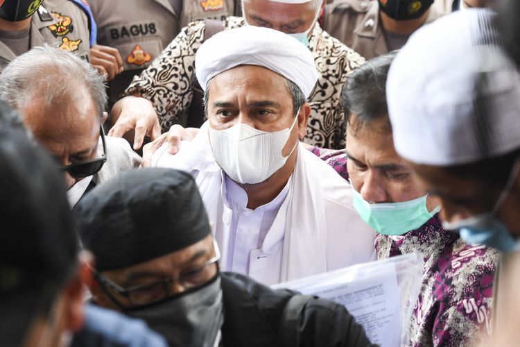 Pemimpin Front Pembela Islam (FPI) Habib Rizieq Shihab (tengah) bersiap menjalani pemeriksaan di Mapolda Metro Jaya, Jakarta, Sabtu (12/12/2020). 
