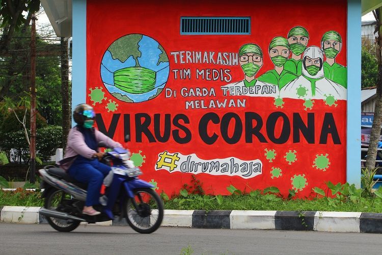 Seorang pengendara motor melintas di depan mural tentang pandemi COVID-19 di Pontianak, Kalimantan Barat, Kamis (29/4/2021). Mural yang dibuat oleh warga setempat itu untuk memberikan dukungan atas perjuangan tim medis yang selama ini berada di garis terdepan dalam penanganan COVID-19 khususnya di PontianaK  