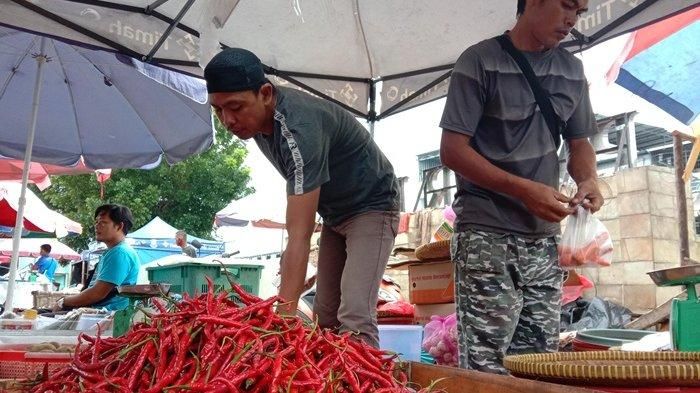 Alex (39) pakai topi. pedagang cabai di Pasar Pagi Kota Pangkalpinang tampak melayani para pembeli, Rabu (14/7/2021)  