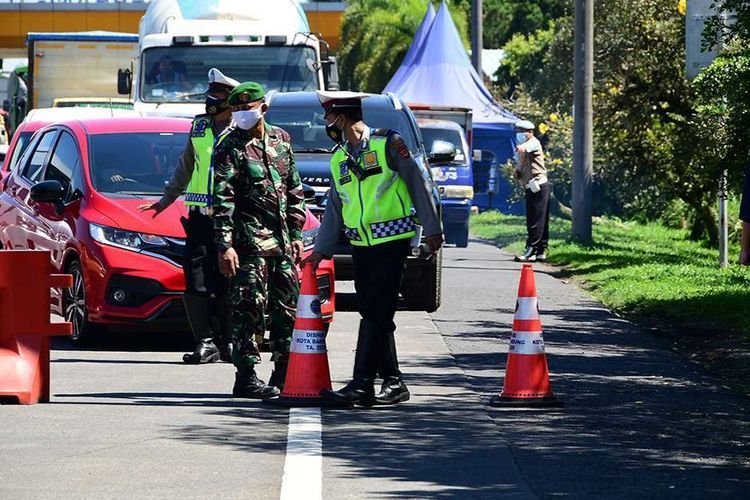 Petugas melakukan penyekatan kendaraan di depan Gerbang Tol Pasteur, Kota Bandung, Jawa Barat, Selasa (6/7/2021). Selama PPKM Darurat, Kota Bandung tertutup bagi warga dari luar wilayahnya, hal tersebut dilakukan untuk menekan mobilitas masyarakat dan mengurangi penyebaran Covid-19.(KOMPAS.com/AGIE PERMADI) 