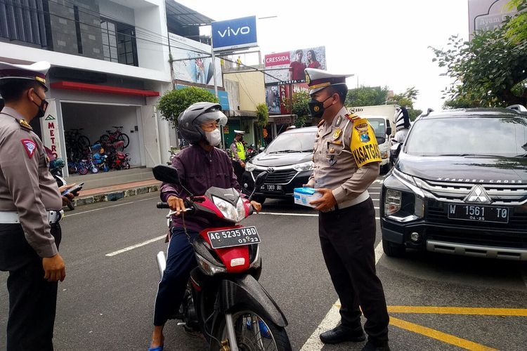 Satlantas Polres Blitar menghentikan pengguna jalan di Jalan Urip Sumoharjo, Kecamatan Wlingi, Kabupaten Blitar, Jumat (26/11/2021) dalam kampanye taat prokes dan vaksin Covid-19.(KOMPAS.COM/ASIP HASANI) 