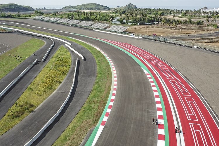 Foto udara pekerja menyelesaikan pengecatan ornamen Pertamina Mandalika International Street Circuit di KEK Mandalika, Kecamatan Pujut, Praya, Lombok Tengah, NTB, Jumat (5/11/2021). Pengecatan sudut trek, kerb dan tepian trek sirkuit Mandalika menggunakan tiga warna penting yakni warna merah putih yang menandakan kerb yang berfungsi sebagai pemandu pembalap di lintasan dan warna hijau yang merupakan track limit atau pembatas trek yang ketika pembalap menyentuh garis tersebut akan dikenakan penalti. ANTARA FOTO/Ahmad Subaidi/aww.(ANTARA FOTO/AHMAD SUBAIDI) 