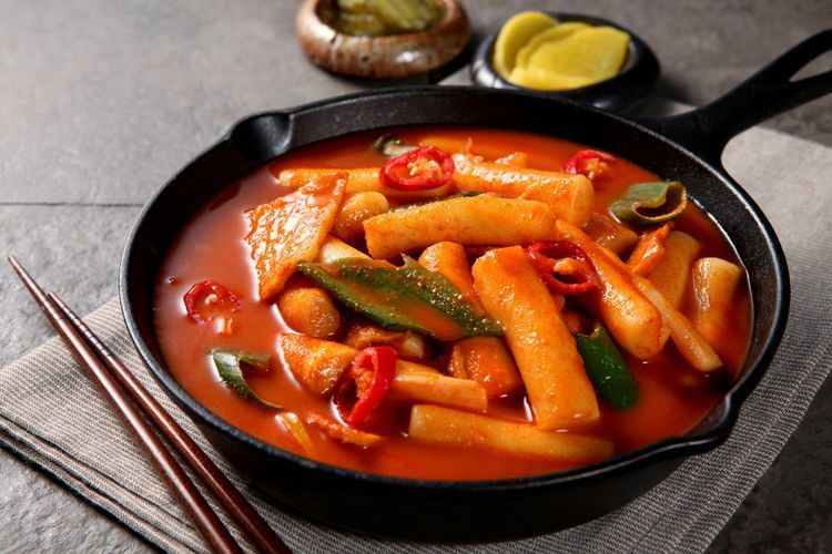 Ilustrasi sepiring tteokbokki saus gochujang, kuliner khas Korea Selatan. 