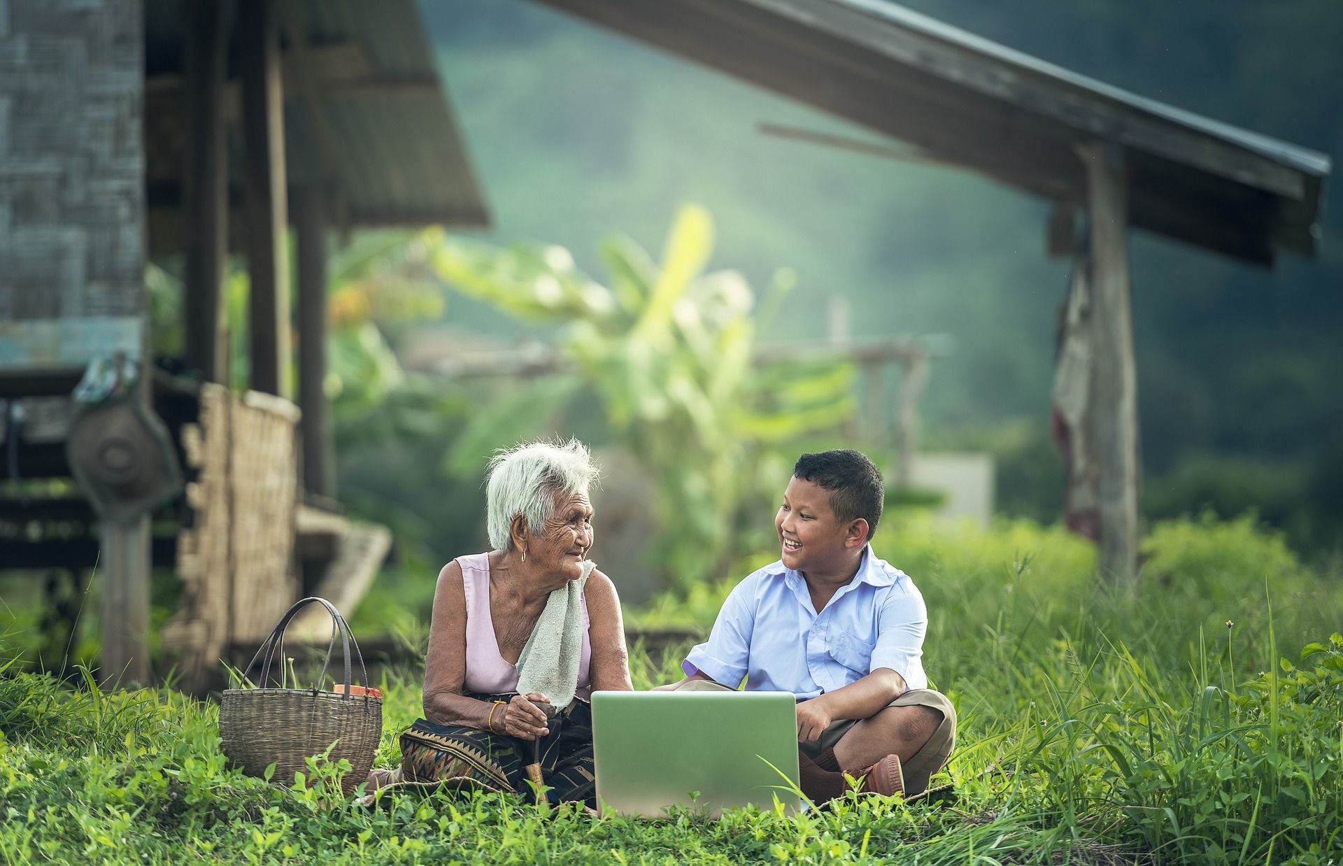 contoh kehidupan sehari hari seorang anak memegang laptop di pedesaan bersama neneknya