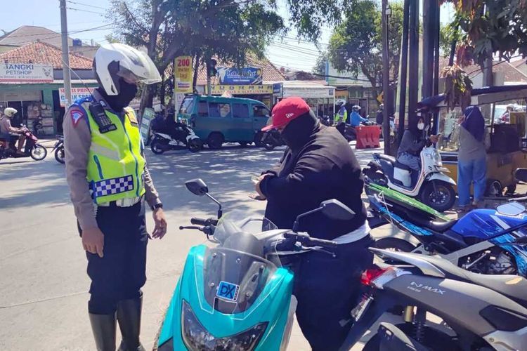 Sejumlah petugas kepolisian dari Satlantas Polresta Bandung kembali menerapkan tilang manual di Soreang, dalam operasi tersebut sebanyak 45 pelanggaran berhasil ditemukan(KOMPAS.COM/M. Elgana Mubarokah) 