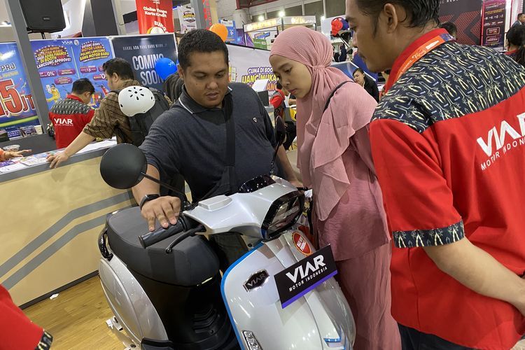 Pengunjung Jakarta Fair 2023 melihat-lihat produk motor listrik baru(Kompas.com/Daafa Alhaqqy) 