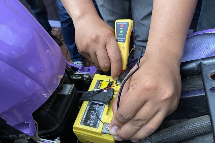 Demonstrasi penggunaan alat pengukur tegangan aki motor(KOMPAS.com/daafa) 