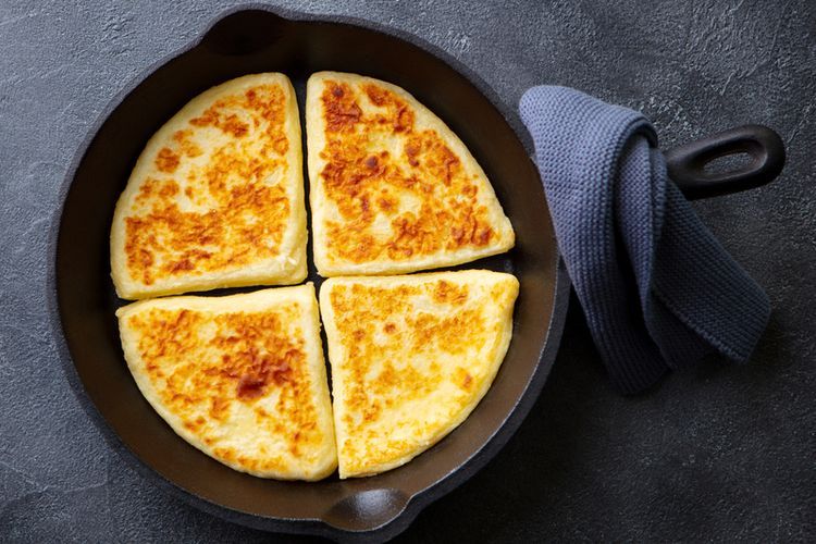 Ilustrasi roti kentang dimasak dengan wajan datar.   