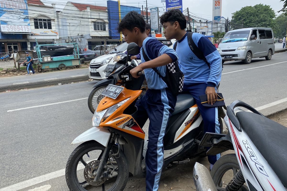 Pelajar SMP di bawah umur mengendarai motor sembari merokok dan tidak menggunakan helm (Kompas.com/Daafa Alhaqqy)  