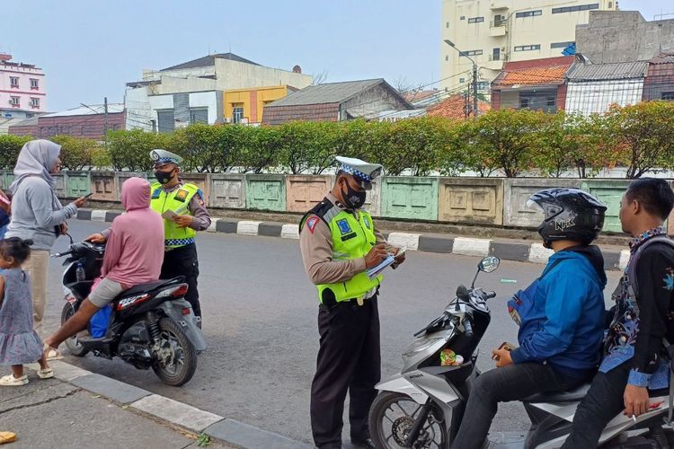 Sejumlah pemotor ditilang karena tak mengenakan helm saat melintas di depan Stasiun Pasar Minggu, Jakarta Selatan, Kamis (21/9/2023).(KOMPAS.com/Dzaky Nurcahyo) 